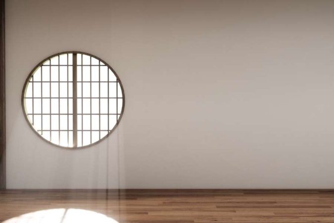Parquet en bois clair exposé à la lumière directe du soleil par une fenêtre ronde, une des erreurs qui abîment votre parquet.